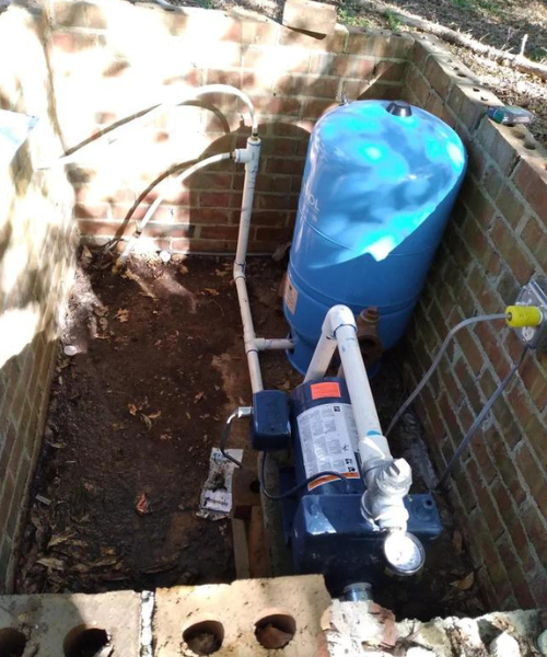 A blue water tank sitting next to a brick wall